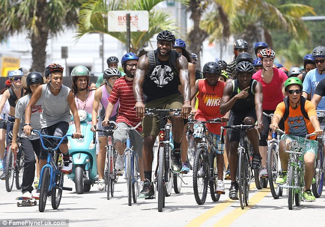 This way! LeBron leads a group of cyclists through the streets of Miami for the commercial