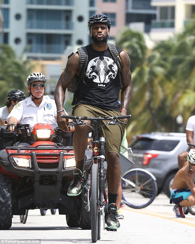 Muscle-guy: LeBron flexes his massive arms on his bike