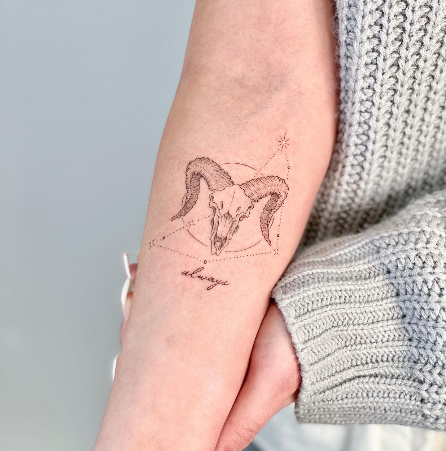 Single needle ram skull and Capricornus constellation tattoo on the inner forearm