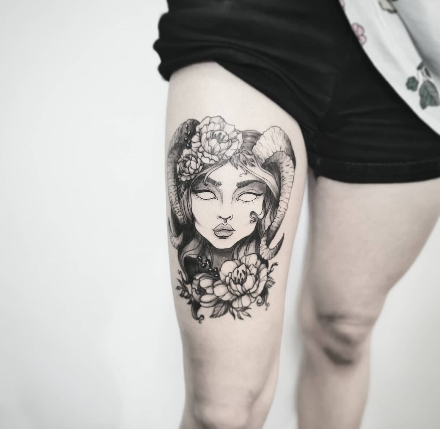 Capricorn Goddess and flowers tattoo located on the thigh