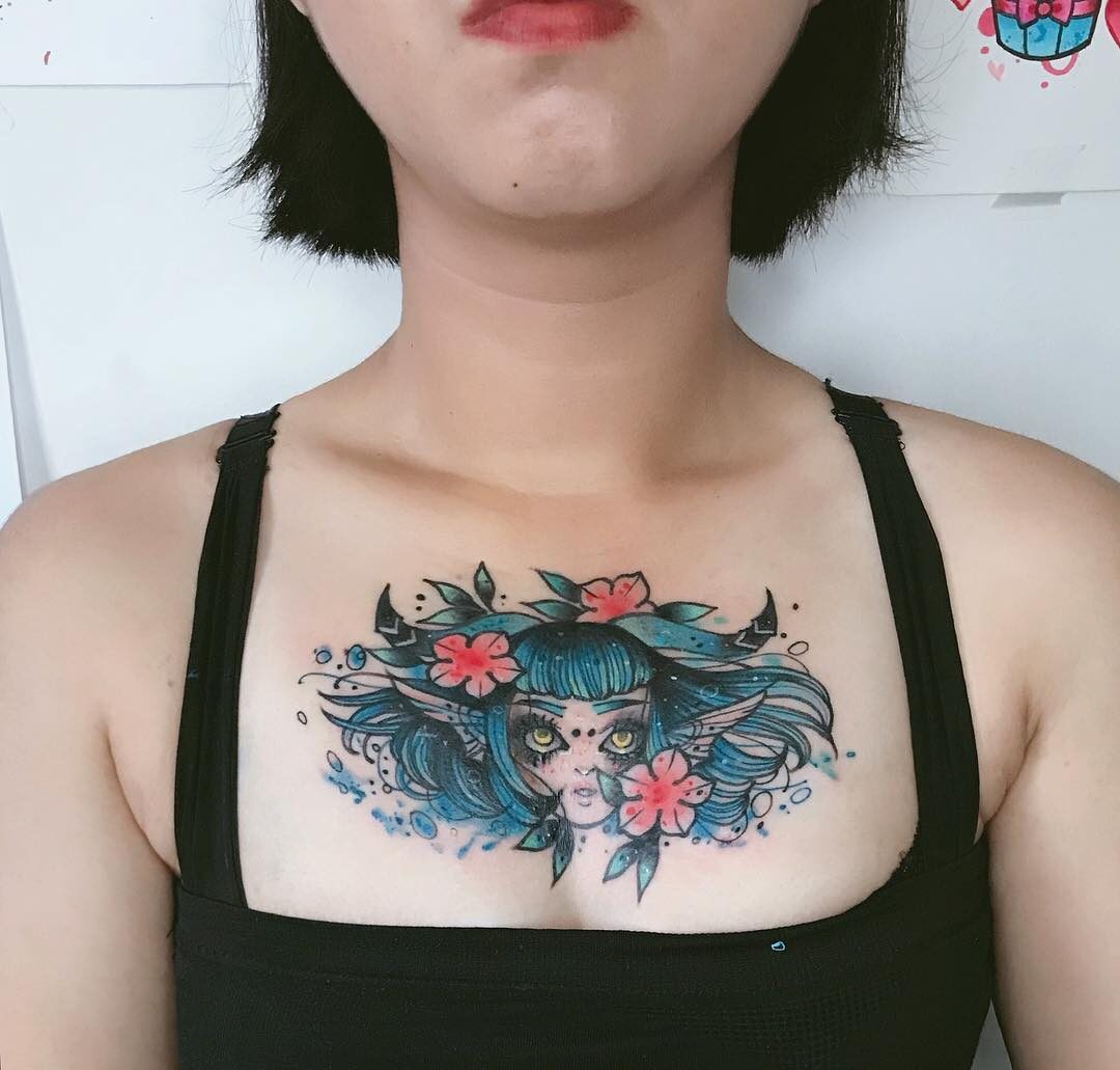 Blue inked Capricorn Goddess and flowers tattoo on the chest