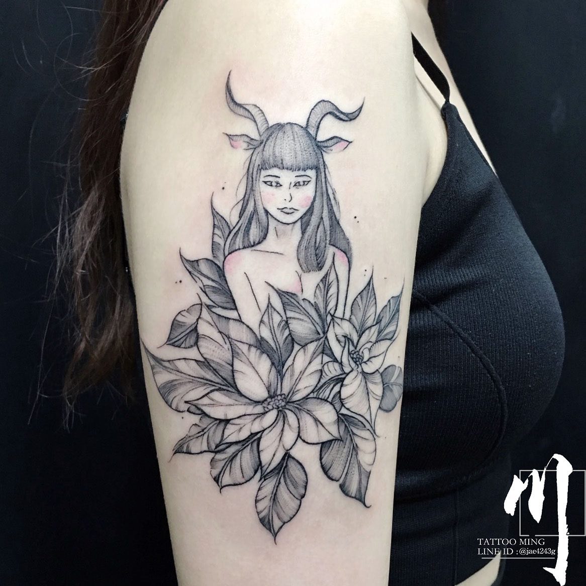 Capricorn Goddess and flowers tattoo located on the outer arm