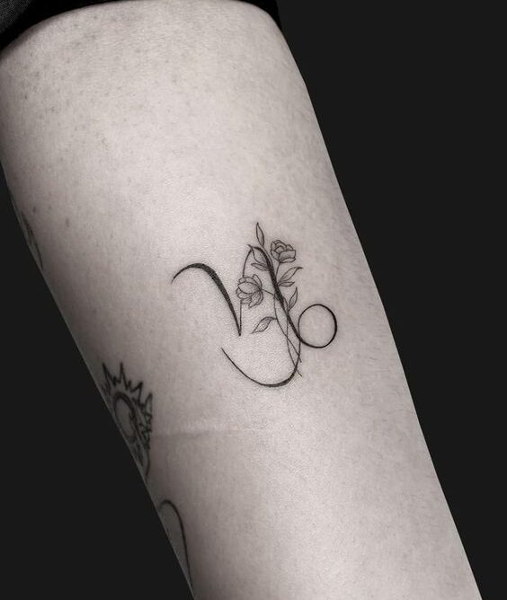 Capricorn zodiac symbol with flowers tattooed on the forearm