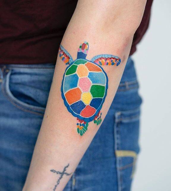 Watercolor style turtle tattoo on the forearm