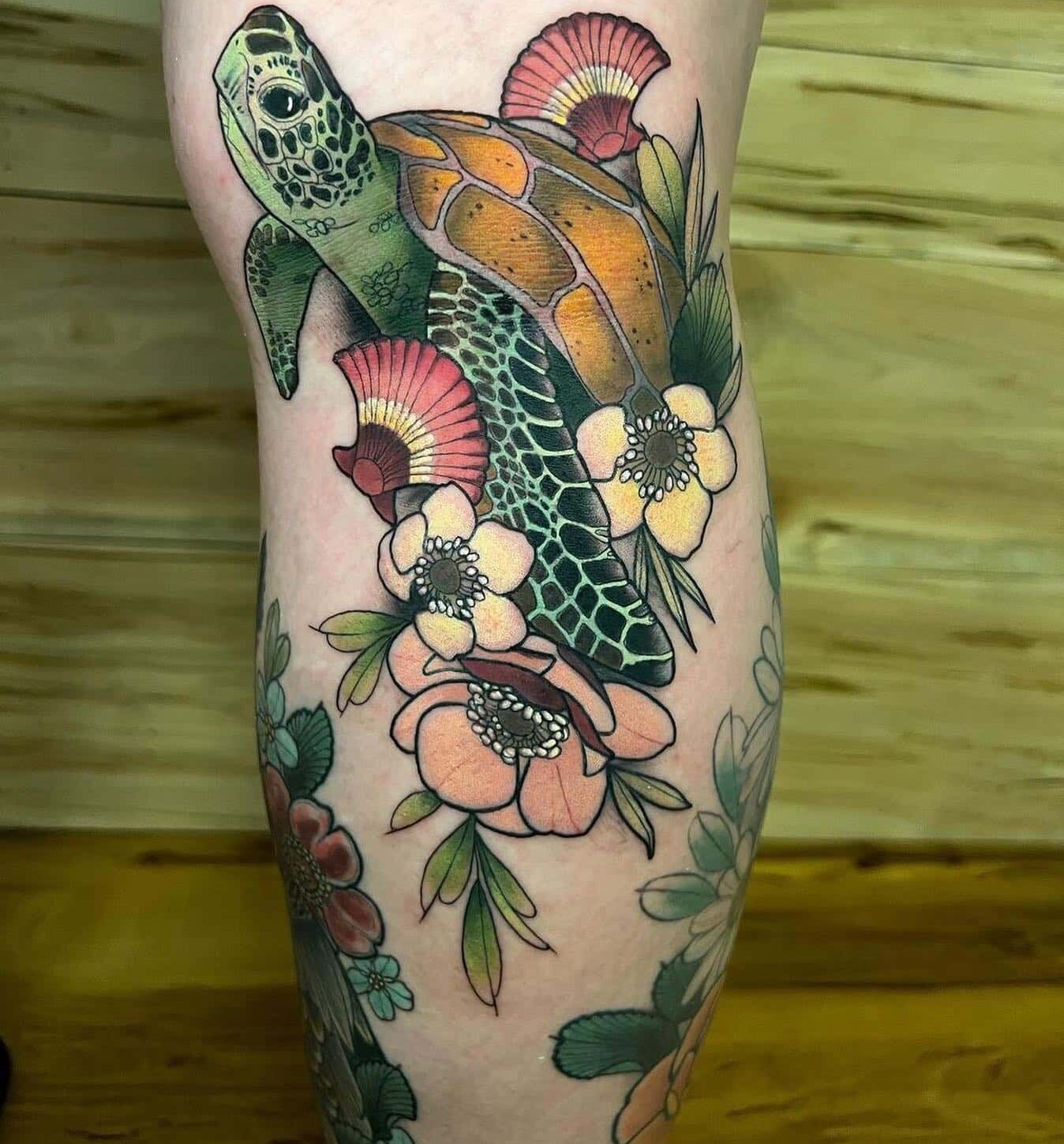 Watercolor style turtle and flowers tattoo on the calf