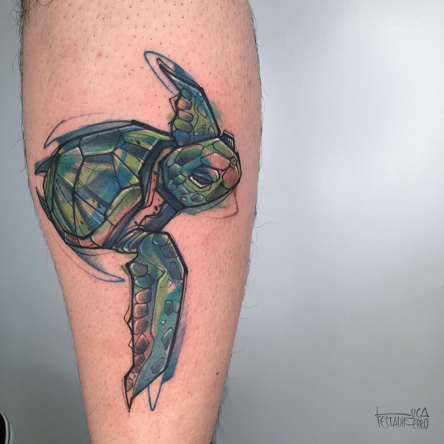 Colored inked turtle tattoo on the calf