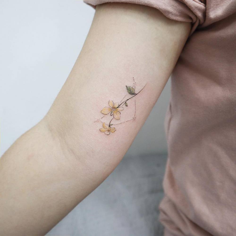 Capricorn constellation with flower tattoo on the right inner arm