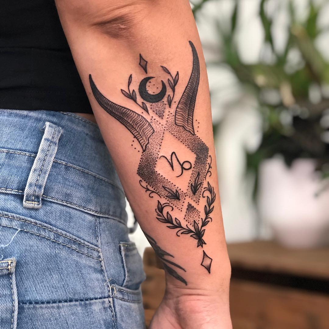 Horn and leaves tattoo on the outer forearm