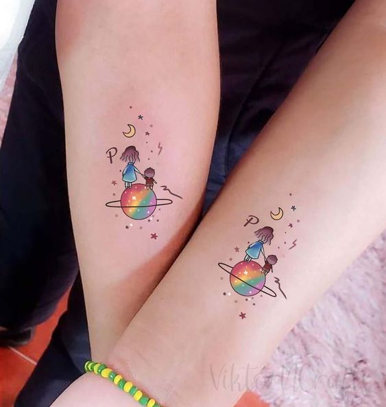 Matching Saturn with mother and daughter tattoo on the inner forearm