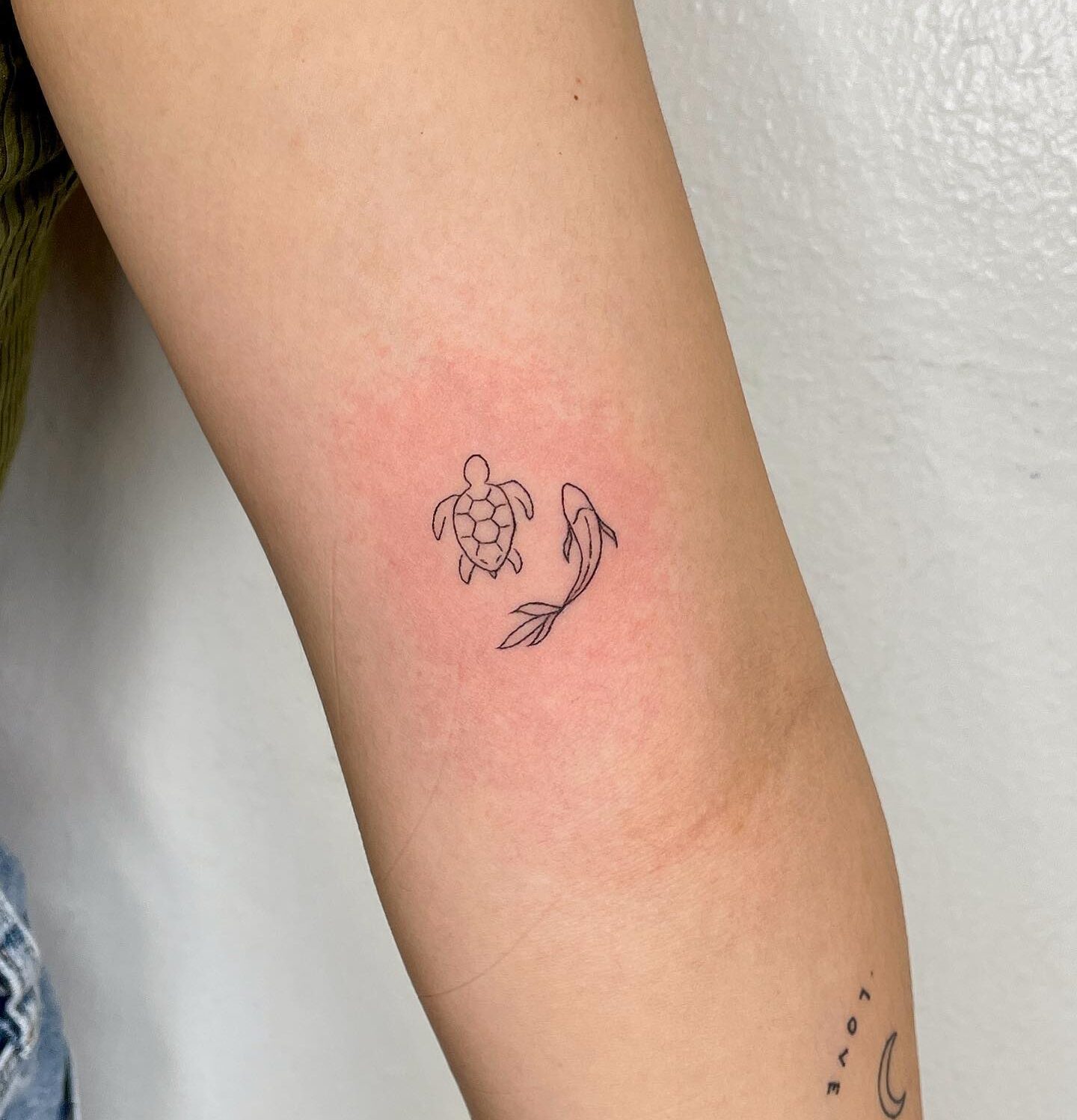 Minimalistic turtle and koi fish tattoo on the inner arm