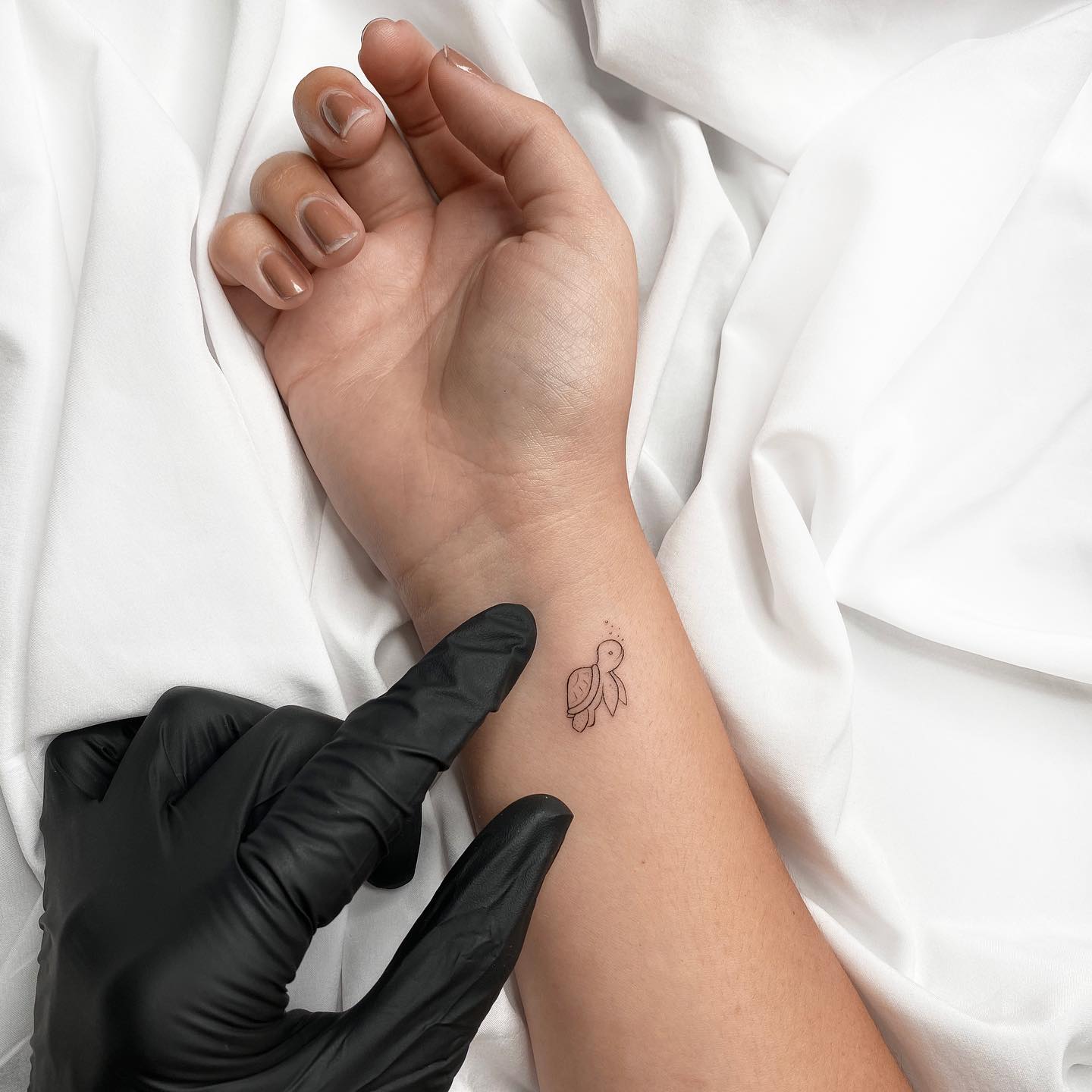 Minimalistic turtle tattoo on the wrist