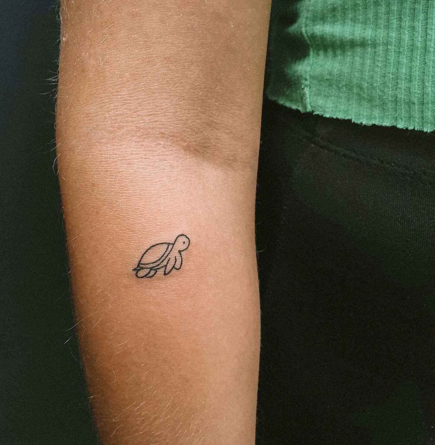 Minimalistic turtle tattoo on the forearm