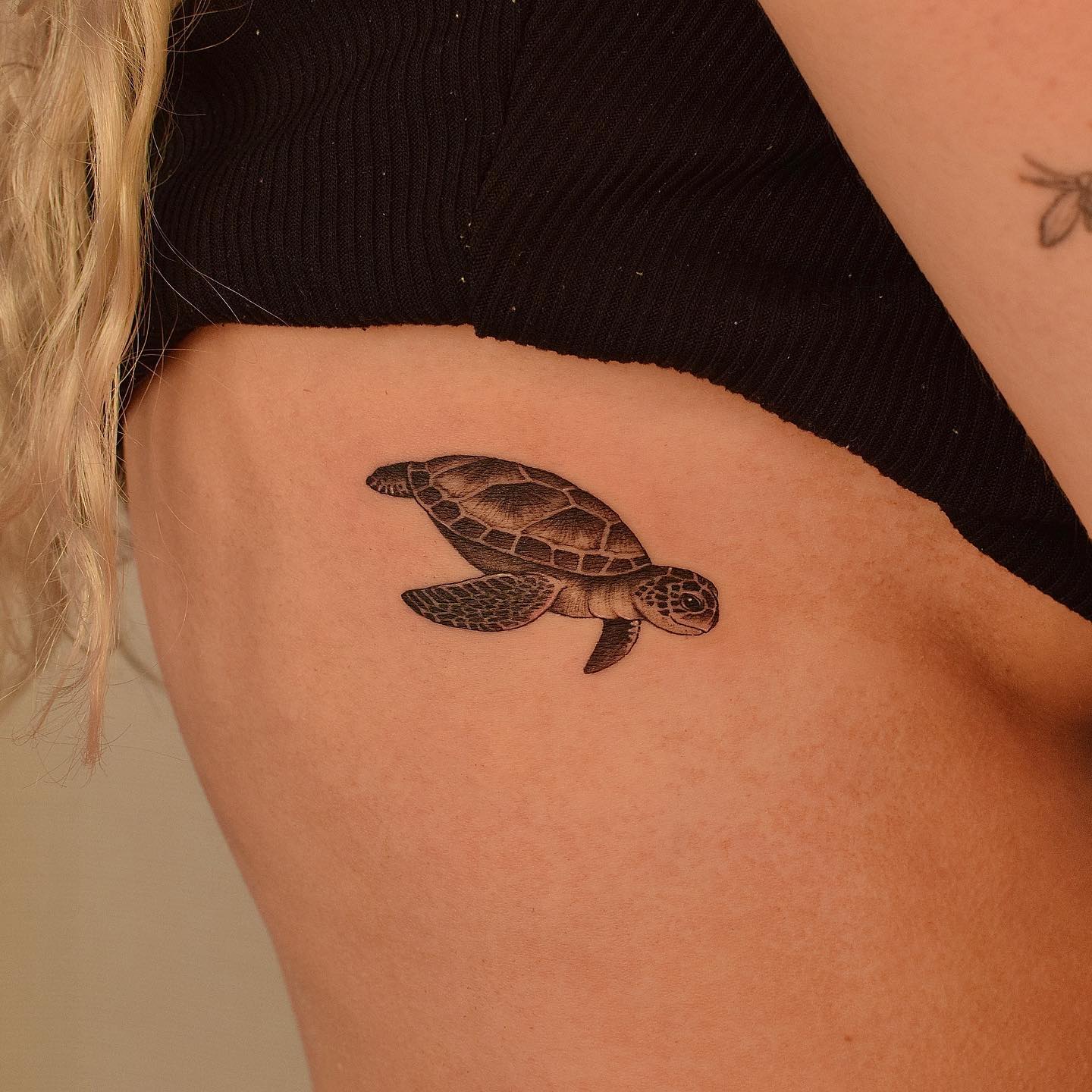 Illustrative style sea turtle tattoo on the ribs