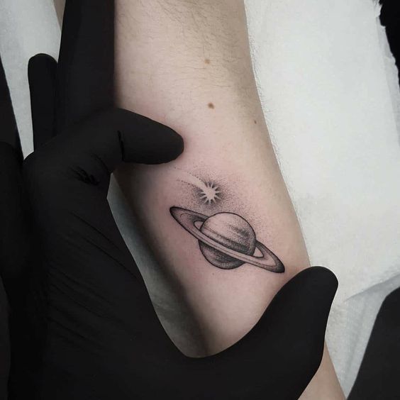 Planet Saturn tattoo located on the forearm