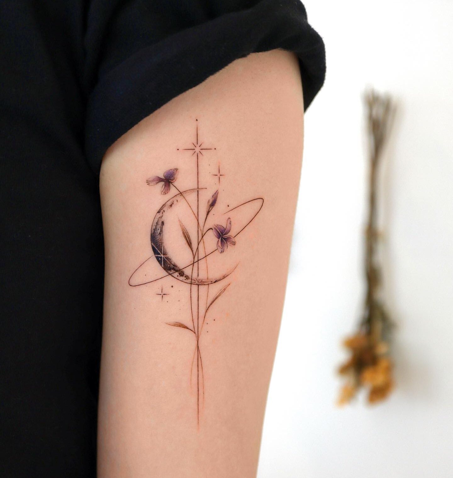 Planet Saturn and flower tattoo on the outer arm