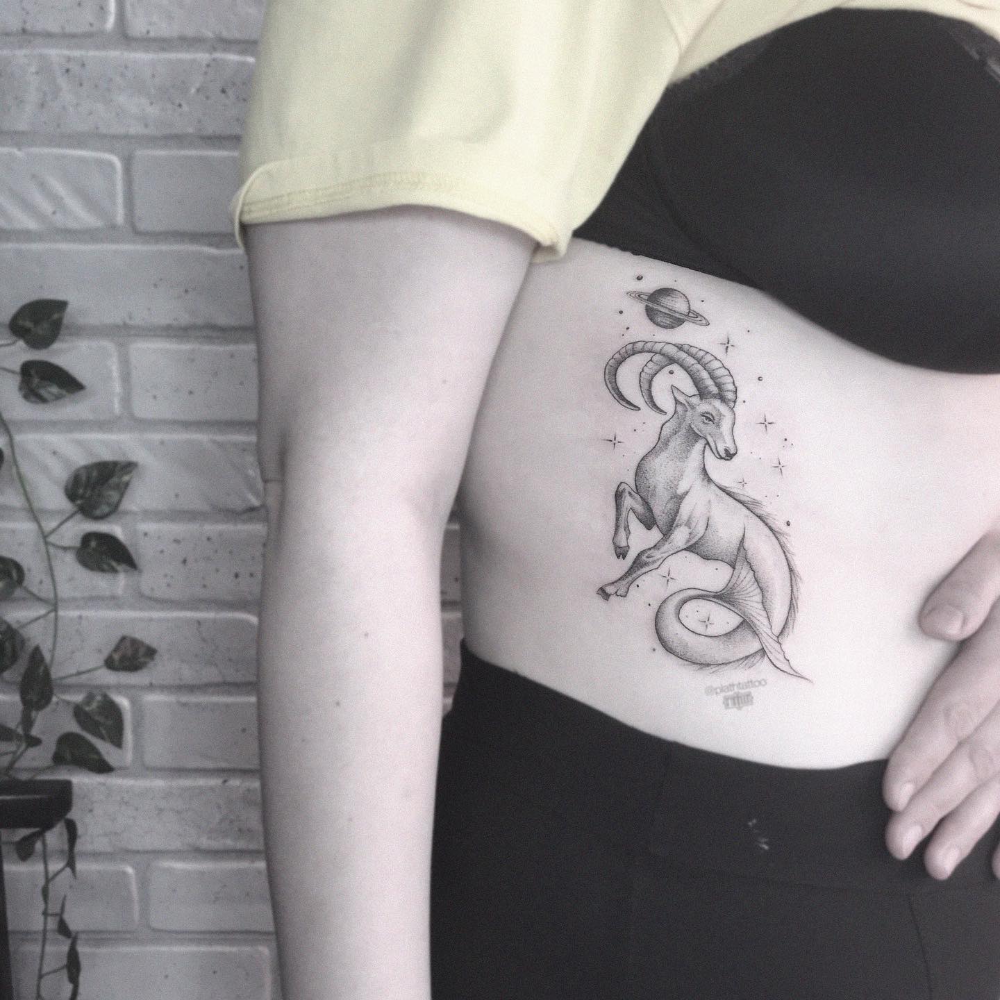 Sea goat and Saturn tattoo located on the rib