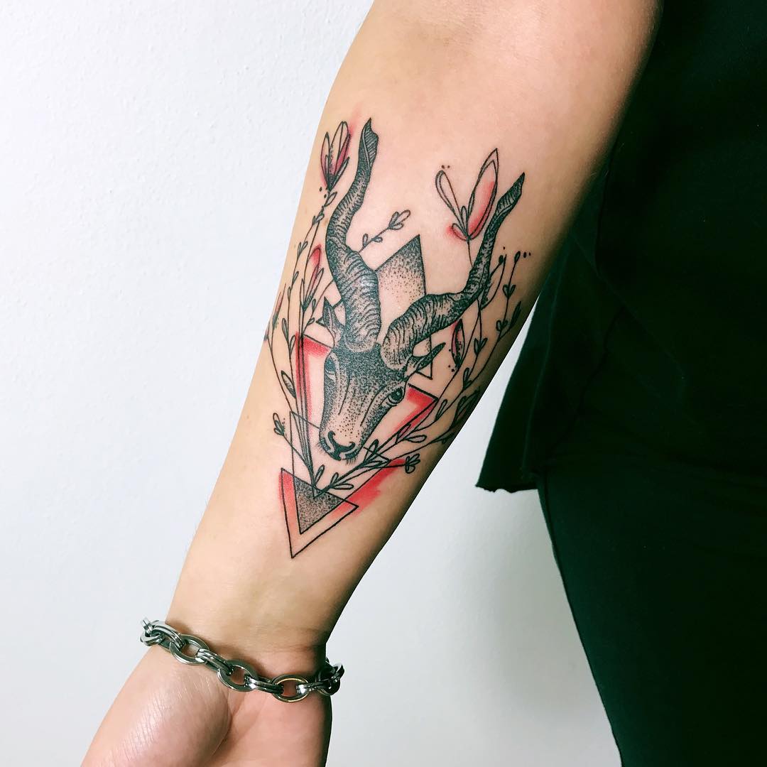 Black and red inked sea goat tattoo on the inner forearm