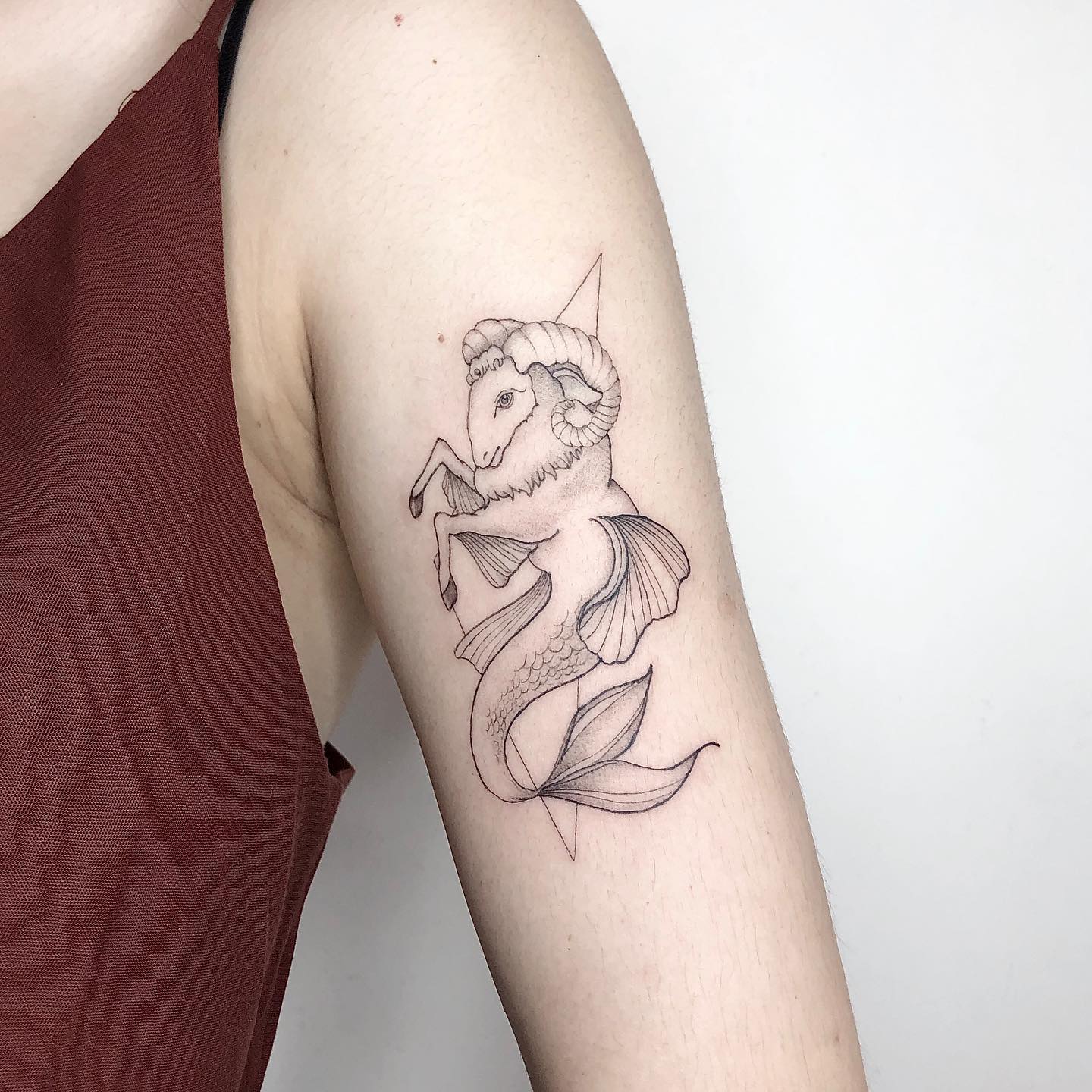 Sea goat tattoo located on the upper arm