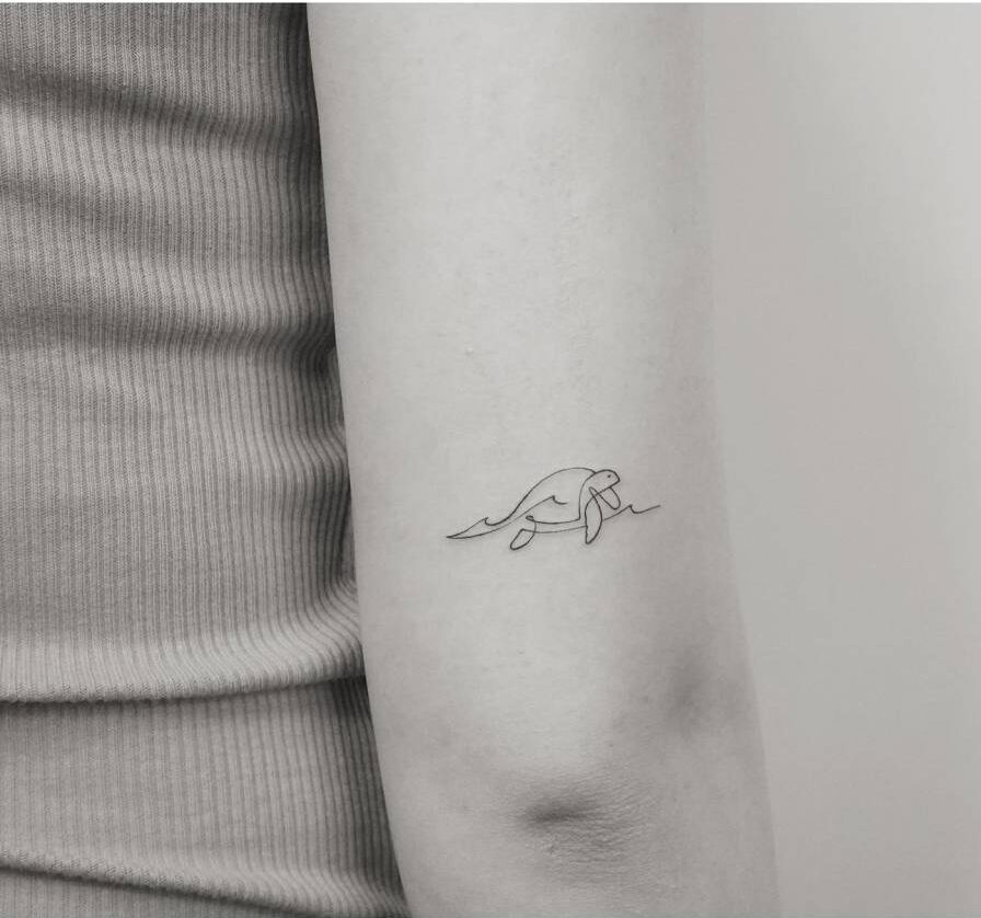 Continuous line sea turtle tattoo on the inner arm