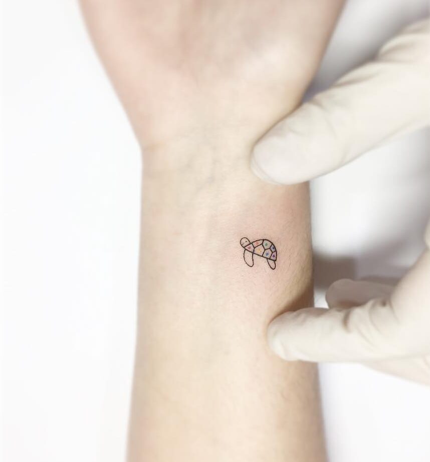 Small and minimalist turtle tattoo on the wrist