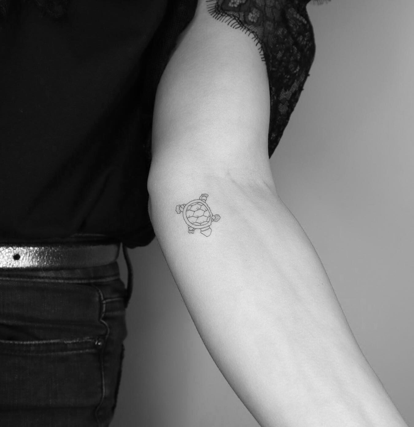 Fine line turtle tattoo on the inner forearm