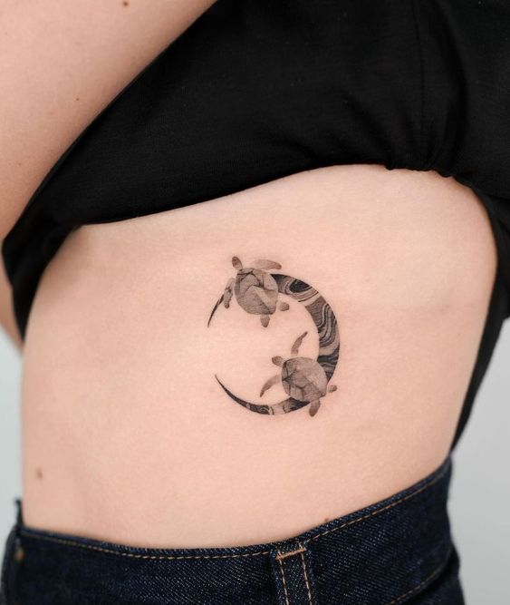 Two sea turtles and moon tattoo on the ribs
