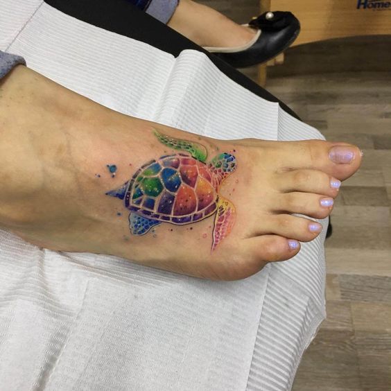Watercolor style sea turtle tattoo on the foot