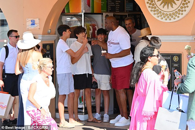 A group of young fans are clearly excited to meet Magic Johnson at a local gelataria