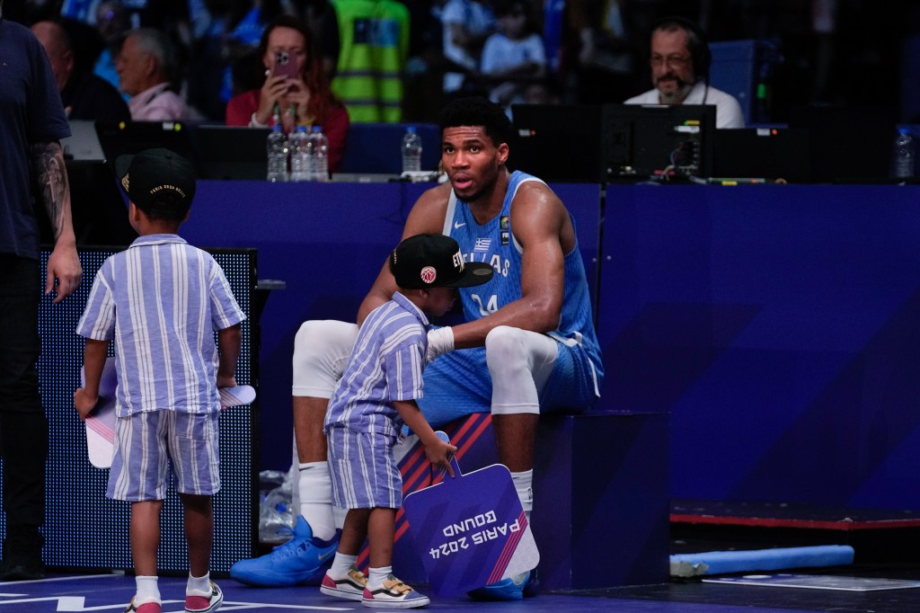 Greece's Giannis Antetokounmpo, sits with his children after his team qualified for the Paris 2024 Olympics eliminating Croatia, following a FIBA Olympic Qualifying basketball final.