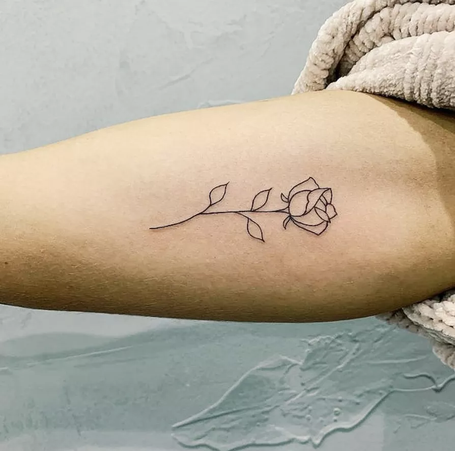 minimalist rose tattoo on forearm