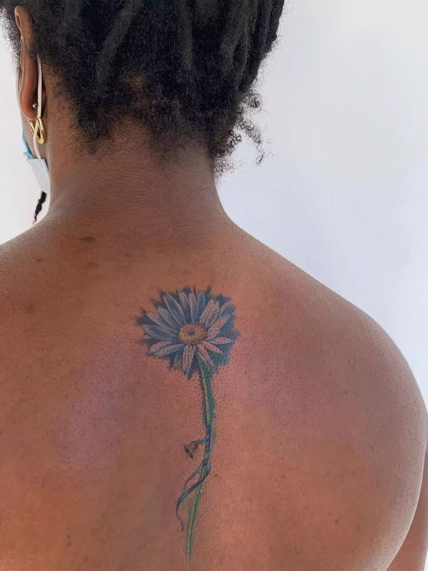 blue flower tattoo on spine