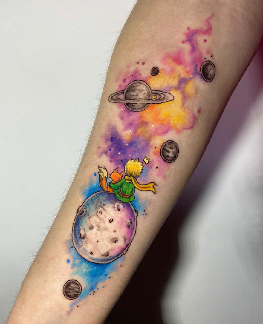 little prince with a fox sitting on the planet colorful tattoo on the arm