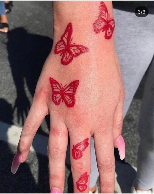 Five red butterfly flying from hand to finger tattoo