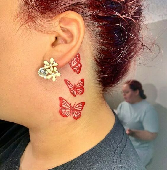 Three red butterfly neck tattoo