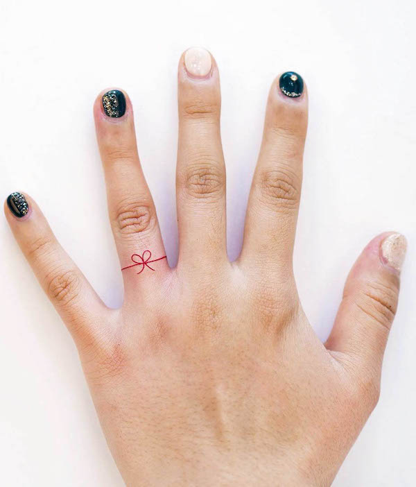 Tiny ribbon wedding ring tattoos by @overthe.dal