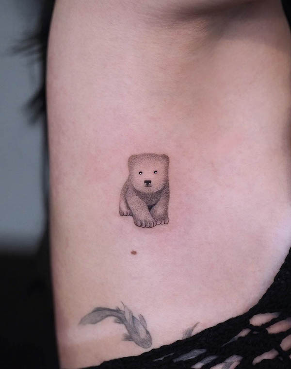 Tiny polar cub rib tattoo by @ura.ttt