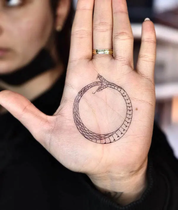 Striking ouroboros palm tattoo by @berkayerkul