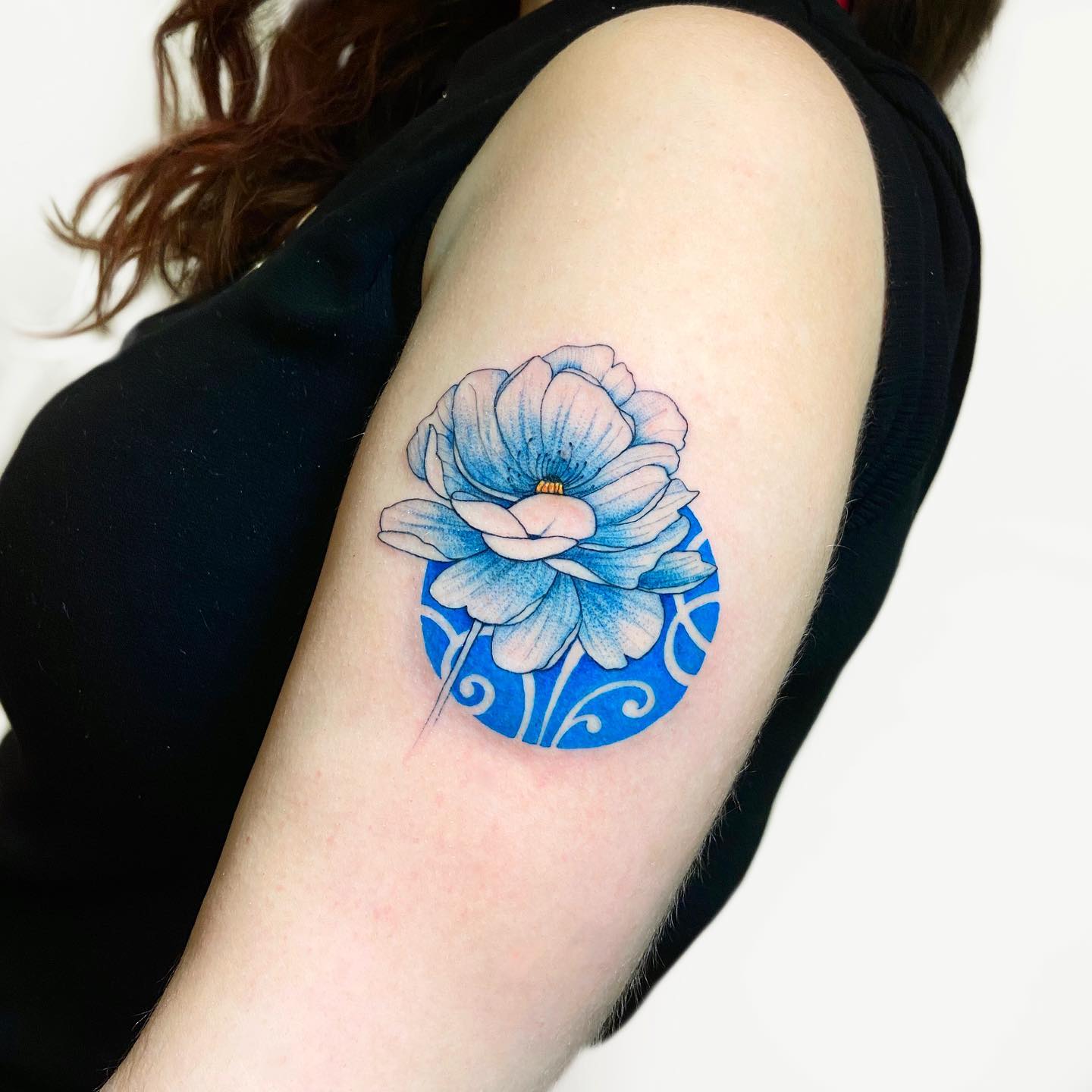 Blue peony tattoo located on the upper arm