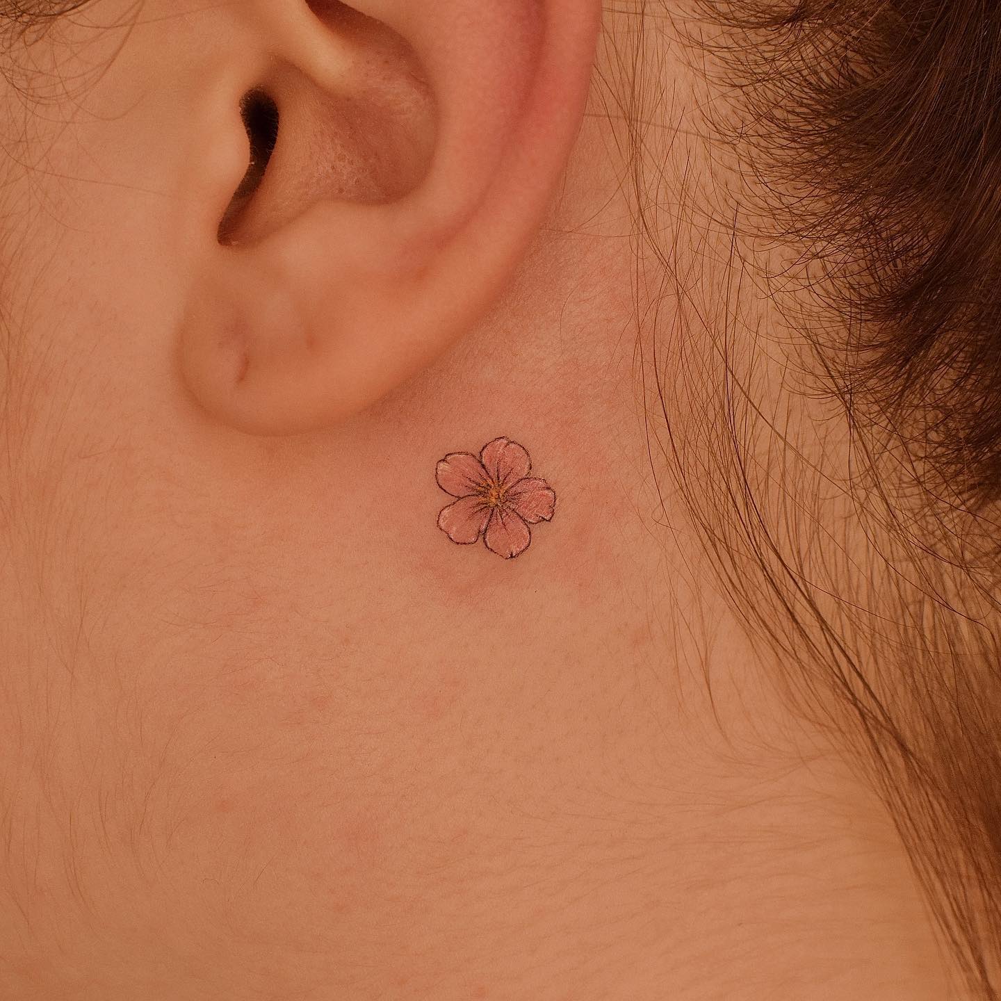 Illustrative style cherry blossom tattoo behind the ear