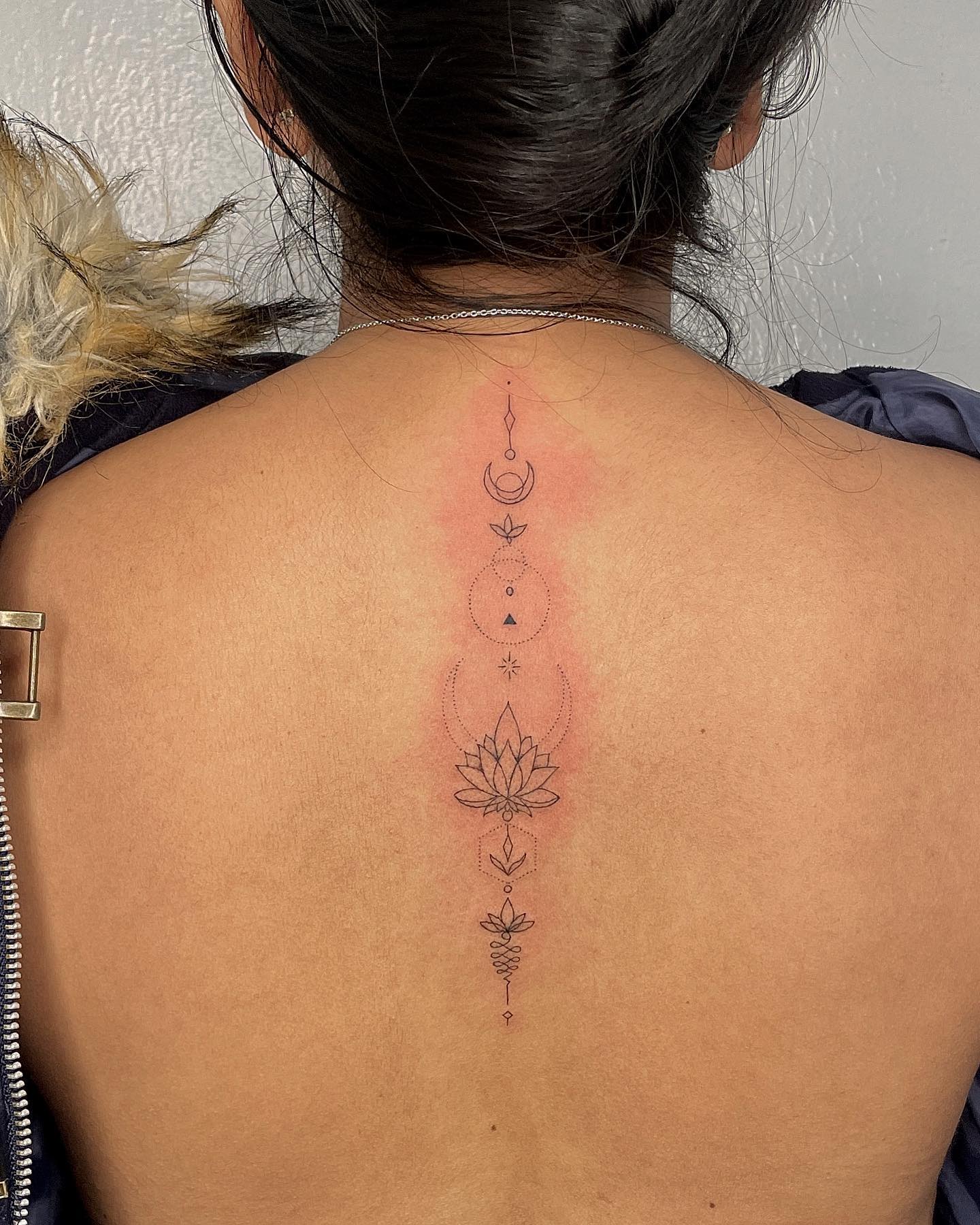 Ornamental flower and moon tattoo on the spine