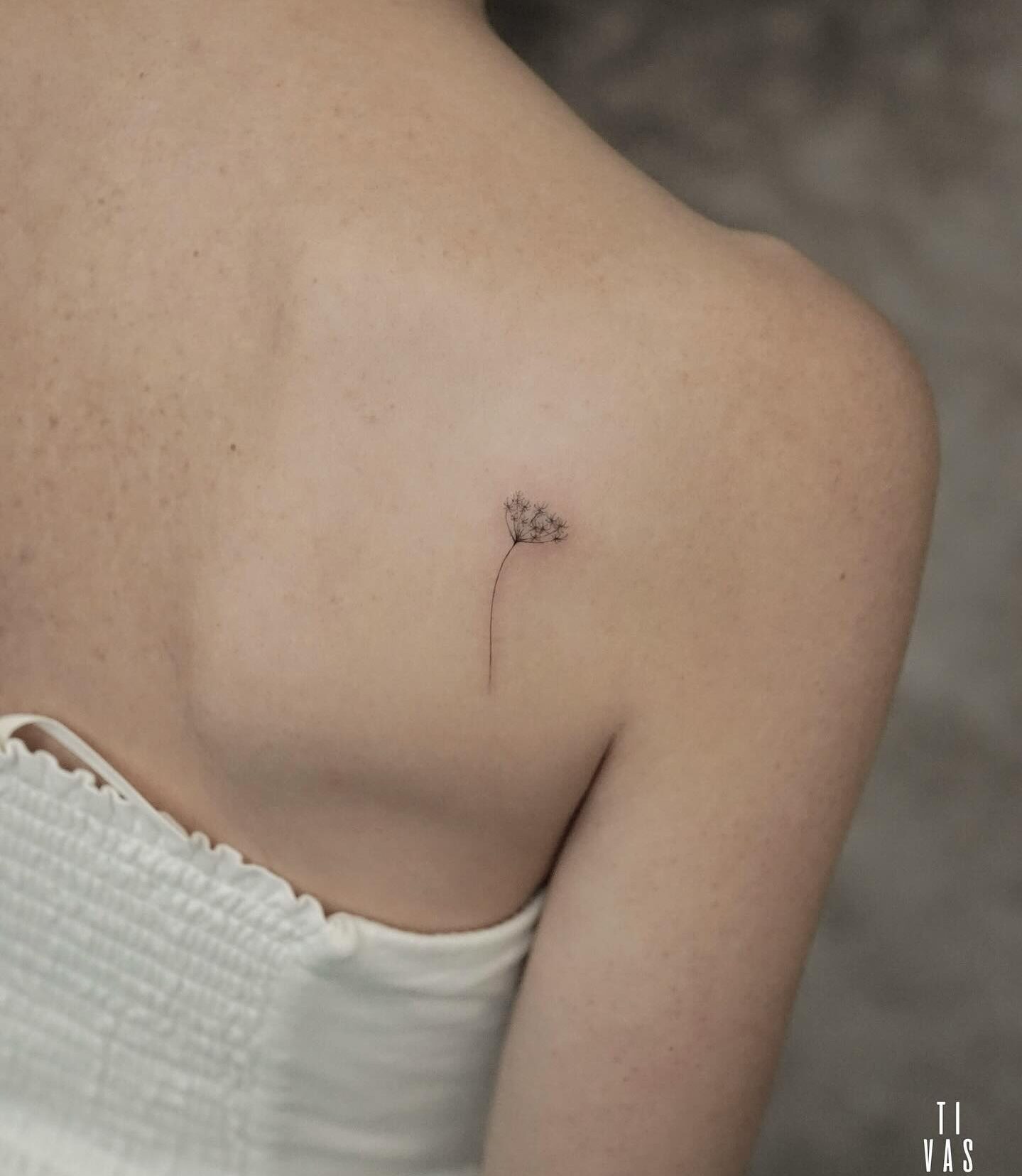 Fine line style dandelion tattoo on the back shoulder