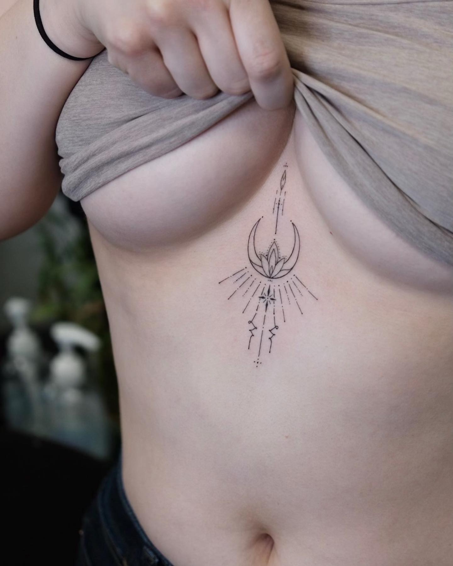 Ornamental flower moon tattoo located on the sternum